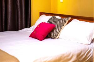 a pink pillow sitting on top of a bed at Hecahomes in Kericho