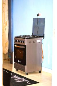 a stove with a laptop on top of it at Hecahomes in Kericho