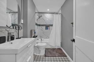 ein weißes Badezimmer mit Toilette und Dusche in der Unterkunft Airport Subway Condo in Boston