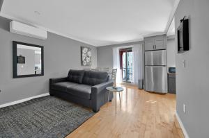 ein Wohnzimmer mit Sofa und eine Küche in der Unterkunft Airport Subway Condo in Boston