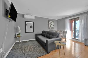 ein Wohnzimmer mit Sofa und Tisch in der Unterkunft Airport Subway Condo in Boston