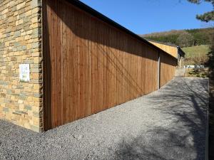 a wooden garage door next to a brick building at Eh ma biche in Stoumont