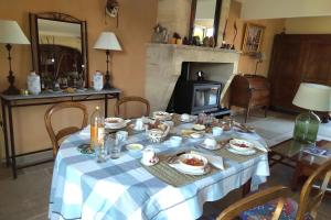 a dining room table with a blue and white table cloth at Mas des Treilles - Chambre d'hôtes "Côté Villages" in Mane