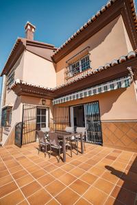 a patio with a table and chairs on a house at Villa Oropéndola para familias, a pocos minutos de Granada, Piscina agua salada, Parking privado, Barbacoa, Chimenea, 14 pax in Belicena