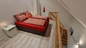 ein rotes Sofa in einem Zimmer mit Treppe in der Unterkunft Haus Chresten in Büllingen