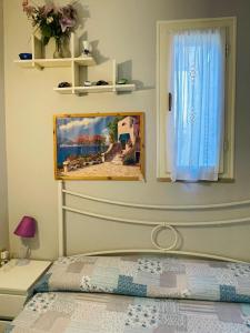 a bedroom with a bed and a window at Pisolo in Procchio +12 photos