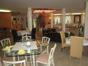 a dining room with tables and chairs and a restaurant at Apparthotel am Friedrichspark in Bad Pyrmont