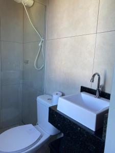 a bathroom with a sink and a toilet and a shower at Hotel Linassi in Cruz Alta