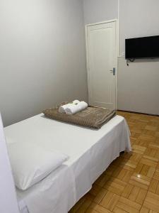 a bed with two towels on it in a room at Hotel Linassi in Cruz Alta