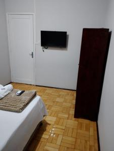 a bedroom with a bed and a flat screen tv at Hotel Linassi in Cruz Alta