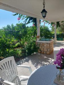 a patio with a table and chairs and flowers at VisForYou Apartments in Vis