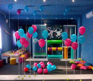 a room with pink and blue balloons and a playground at Luna in Prokuplje