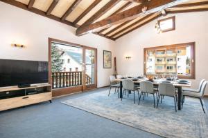 a dining room with a table and chairs and a flat screen tv at Le Chalet in Les Deux Alpes +33 photos
