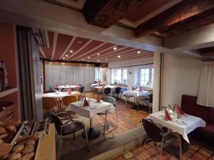 a restaurant with tables and chairs in a room at Schiefes Haus in Ulm