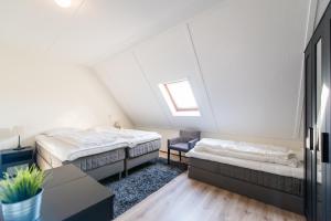 a attic room with two beds and a table at Vleijenhof Type C in Buren