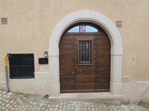 an arched wooden door in a building at Dimora Di Davide in LʼAquila +5 photos