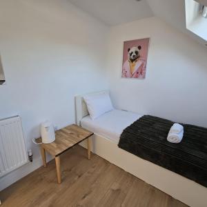 a small room with a bed and a small table at Albion's House in Luton