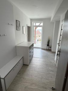 a white kitchen with a counter and a table at Hradňanka Food&Beer in Predmier