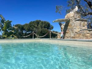 a person is standing next to a swimming pool at Pisolo in Procchio