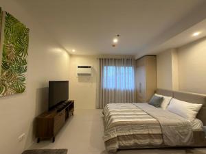 a bedroom with a bed and a flat screen tv at Matina enclaves condo studio type 6thfloor in Davao City