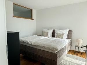 a bedroom with a bed with white sheets and a mirror at Ferienwohnung Ufertraum am Dümmer See in Lembruch