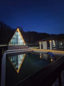 a house with a swimming pool at night at Kozara Resort in Gornji Podgradci
