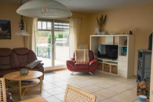 a living room with a couch and a television at Strandstr 4b "Likedeeler 2" in Zingst