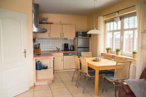 a kitchen with a table and chairs in a kitchen at Strandstr 4b "Likedeeler 2" in Zingst