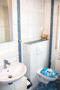 a white bathroom with a sink and a toilet at Strandstr 4b "Likedeeler 2" in Zingst +30 photos