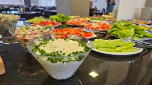 a table topped with bowls of food and plates of vegetables at Ośrodek Uzdrowiskowy Biawena in Wysowa-Zdrój +69 photos