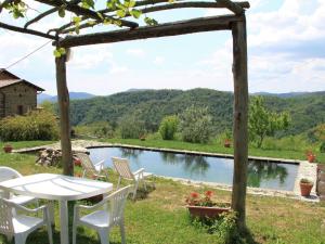 MulazzoにあるAlluring Holiday Home in Canossa with Pool Garden Barbecueのプールサイドのパティオ(テーブル、椅子付)