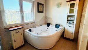 a large white tub in a bathroom with a window at Penthouse Meeresrauschen in Dierhagen +36 photos
