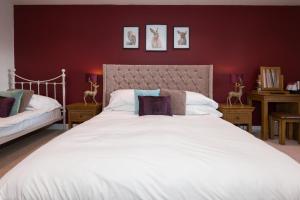 a bedroom with a large white bed and two tables at Sandfordarms in Appleby