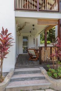 an outdoor deck with a chair and a table at Reve Island Lodge in Grand Anse