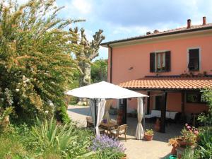 MulazzoにあるAlluring Holiday Home in Canossa with Pool Garden Barbecueの傘付きのパティオ、家