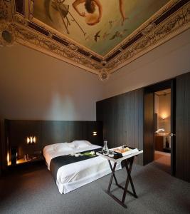 a bedroom with a bed and a table with a ceiling at Caro Hotel in Valencia +55 photos