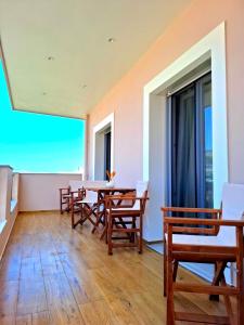 a room with wooden tables and chairs and a large window at Maelia Samos Apartment in Ríva