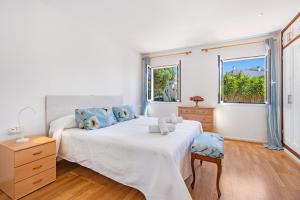 a white bedroom with a large bed and a window at Casa Masi by 3VILLAS in Son Parc +28 photos