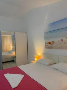 a bedroom with a large white bed with a mirror at Vaya Zorba Studios in Skiathos
