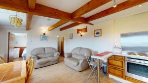 a living room with two chairs and a table at C19 Old Range, Riviere Towans in Hayle