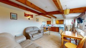 a living room with a couch and a table at C19 Old Range, Riviere Towans in Hayle