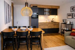 a kitchen and dining room with a table and chairs at Chalet Höfi - Ski-in Ski out at Hörnlilift by Arosa Stay in Arosa