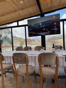 a table with chairs and a large screen in a room at Koçeku Brothers Guest House in Fushë-Lurë