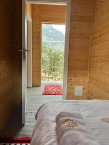 a bedroom with a bed and a large window at Koçeku Brothers Guest House in Fushë-Lurë