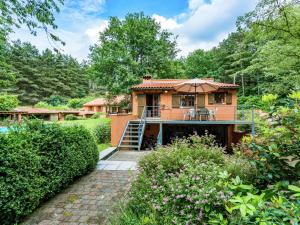 una casa con sombrilla en medio de un jardín en Cosy and snug holiday home with joint swimming pool, en Zichemsveld