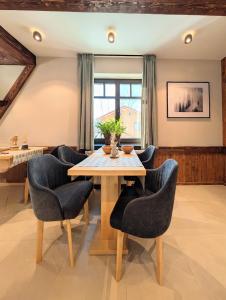 a dining room with a wooden table and chairs at Equus Silvania in Şinca Nouă