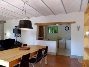 a dining room and kitchen with a wooden table and chairs at La Colombière in Lurcy-le-Bourg
