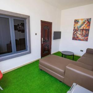 a living room with a couch and green carpet at The Kitchen Kabinet in Abuja
