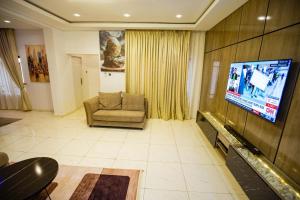 a living room with a couch and a flat screen tv at The Kitchen Kabinet in Abuja