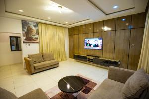 a living room with a couch and a tv at The Kitchen Kabinet in Abuja